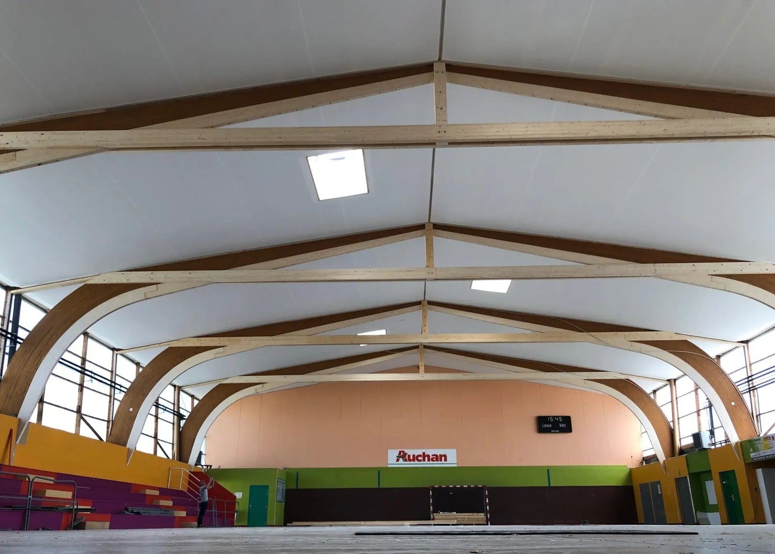 Plafond tendu en toile acoustique Tenseo Comfort AW sous la charpente bois d’une salle de sport